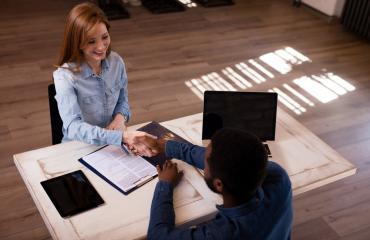 Une étudiante serre la main de son employeur